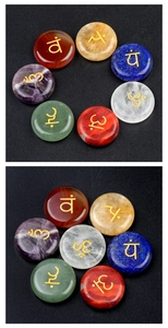 Detailed view of seven chakra polished stones with golden engraved yoga symbols