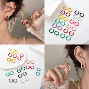 Macro shot of colorful enamel hoop earrings in various shades on white background