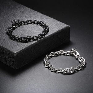 Detailed shot of silver and black stainless steel H-link chain bracelets on black gift box