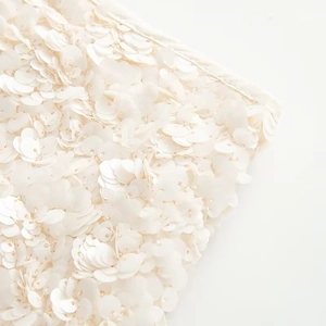 Close-up of white sequin details and layered fabric texture on the casual mini skirt
