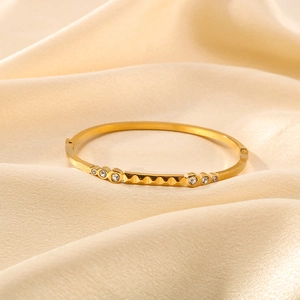 18K gold plated bangle with geometric wave pattern and clear crystals on champagne silk