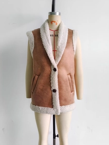 Detailed view of brown faux suede vest with soft white faux shearling collar and lining