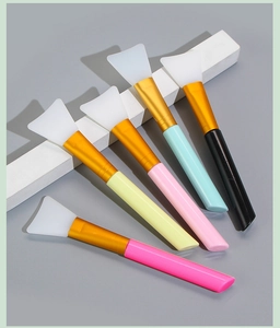 Set of five silicone facial mask brushes with colorful handles and gold ferrules on display