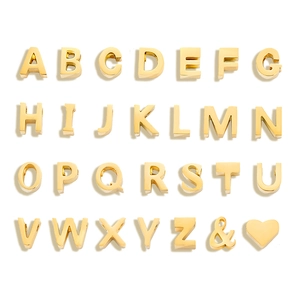 Macro shot of 26 gold titanium steel letters and heart charms for DIY jewelry making