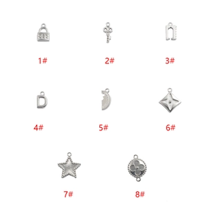 Set of 8 stainless steel DIY jewelry pendants including star, key, and lock charms