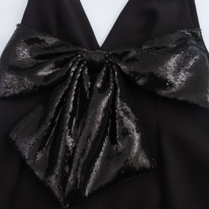 Abito corto nero con scollo a V e un grande fiocco scintillante decorato con paillettes