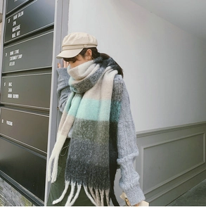 Detail of multi-color striped knitted scarf with long tassels and thick wool texture