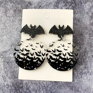 Detail of Halloween bat earrings made of black acrylic with glitter finish and round pendants