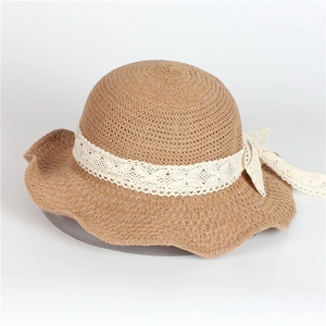 Détail d'un chapeau de paille avec ruban en dentelle blanche et nœud décoratif élégant