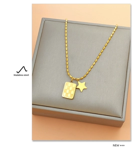 Detailed macro view of gold-plated stainless steel checkered tag and star pendant necklace