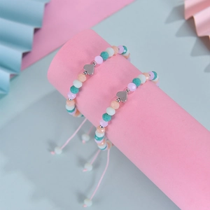 Détail de bracelets en perles de cristal macaron avec breloques cœur argentées en lot
