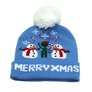Detail of blue knitted Christmas hat with snowman, alien patterns and white pom-pom