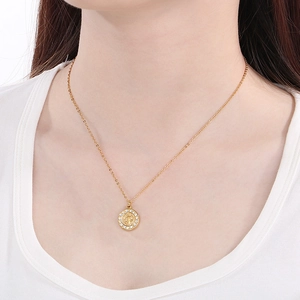 Goldene Medaillon-Kette mit Porträt-Relief und Kristallkranz am Hals eines Models