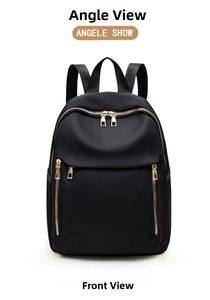 Front view of black minimalist nylon backpack featuring sleek gold metallic zippers