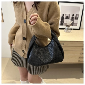 Chic black woven hobo bag styled with a khaki cardigan and checkered pleated skirt