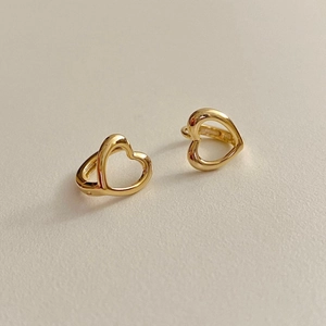 Détail macro de créoles cœur plaquées or 18 carats avec un design lisse et creux