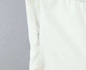 Detail of the high-quality white fabric featuring a seamless invisible side zipper closure