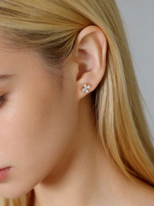 Close-up of minimalist S925 sterling silver four-petal flower stud earrings with zircons