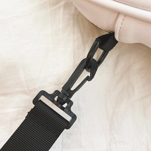 Detail of white PU leather bag featuring black detachable nylon strap and swivel hook