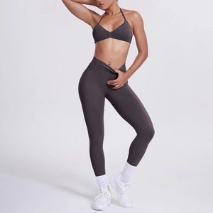 Dettaglio del reggiseno sportivo incrociato e leggings a vita alta grigio antracite