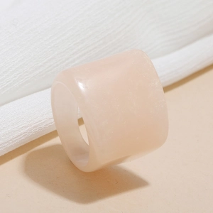 Macro detail of wide peach resin ring with thick band and pearlescent shimmer texture