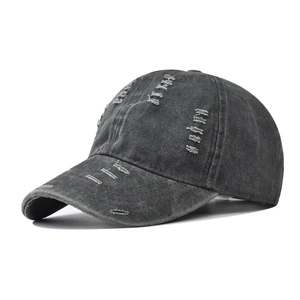Dettaglio del cappello vintage grigio antracite con fori usurati e bordi sfilacciati a mano