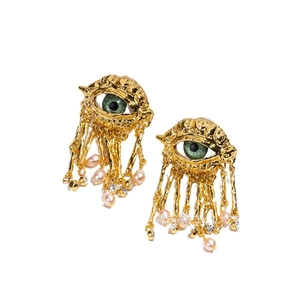 Surrealist gold eye earrings with green crystal pupils and long pearl tassel drops