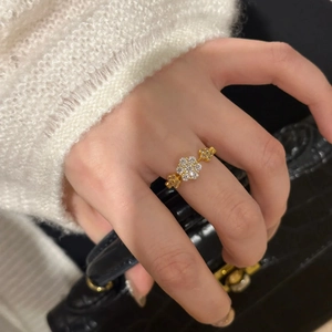 Close-up of golden flower ring with sparkling zircon petals worn on a female hand