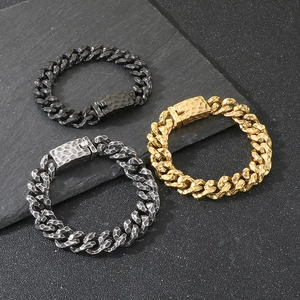 Close-up of vintage hammered textures on gold, black and silver punk cuban chain bracelets