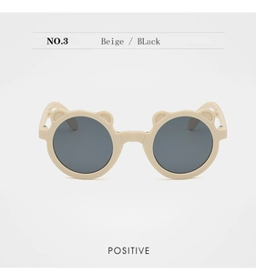 Detail of beige bear-ear folding sunglasses for kids featuring round dark grey lenses