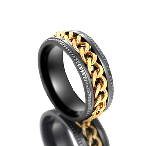 Macro detail of men's spinner ring with black band and gold chain inlay texture