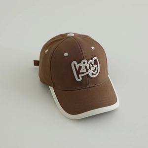 Close-up of brown cotton baseball cap with KING embroidery and white contrast piping