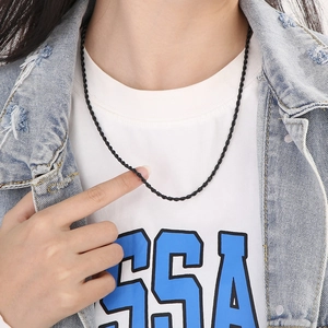 Close-up of a black twisted rope chain necklace worn by a model in a hip-hop style