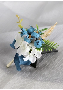 Detail of blue berries and white hydrangea boutonniere with elegant silk ribbons
