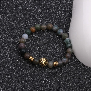 Detail of beaded lion head bracelet with multicolor natural stones on black background