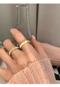 Close-up of enamel pearl rings with gold star detail on a woman finger