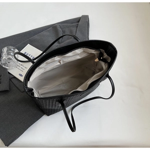 Top view of black woven tote bag interior showing the zipper pocket and fabric lining