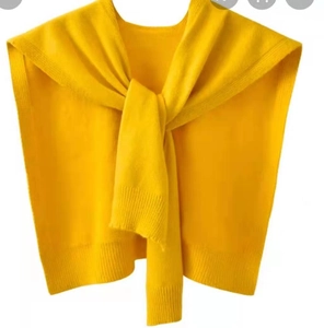 Detailed knit texture of bright yellow core-spun yarn shawl with ribbed edge knot