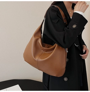 Detail einer braunen Schultertasche aus Leder mit Lychee-Narbung und Metallschnalle
