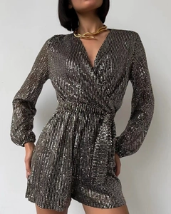 Detail of sequined long-sleeve romper with deep V-neck and decorative gold-black sequins
