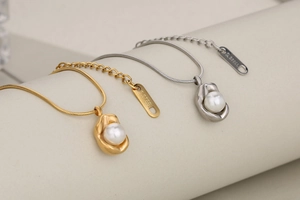 Detailed macro view of gold and silver stainless steel pearl necklaces with snake chains