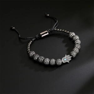Detailed view of braided Hamsa hand bracelet with blue zircon evil eye and silver beads