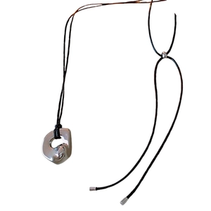 Minimalist irregular silver pendant necklace with adjustable black wax cord on white base