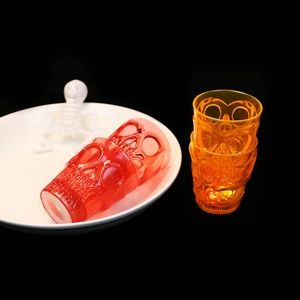 Macro view of stackable skull shot glasses in red and orange for Halloween party barware