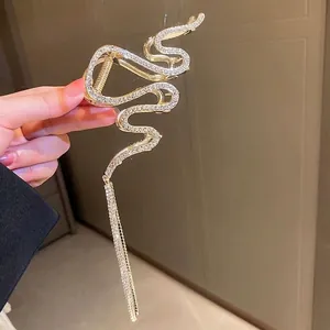 Golden snake-shaped hair claw clip with rhinestones and sparkling tassel pendant