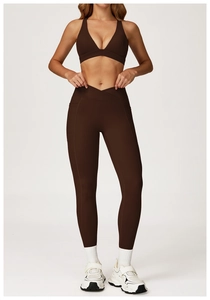 Detail of high-waist brown yoga pants with V-shaped crossover waistband and side pockets