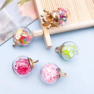 Macro detail of glass bottle charms with colorful star sequins and fruit miniature fillers