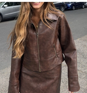Ensemble veste et mini-jupe en similicuir marron porté dans une rue urbaine