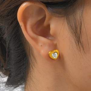 Close-up of heart-shaped 18K gold stainless steel earrings with sparkling white zircon