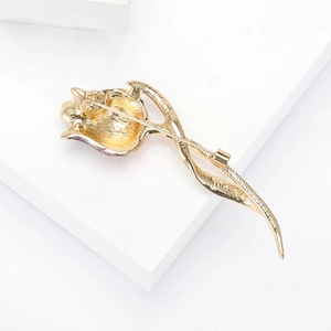 Elegant gold tulip brooch with purple enamel finish and rhinestone details on white background